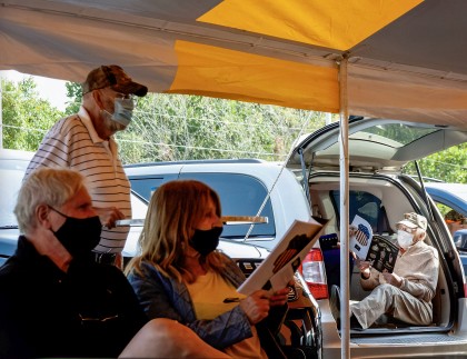 Some bidders made themselves comfortable by popping open the hatch on their vehicles for open‑air seating.