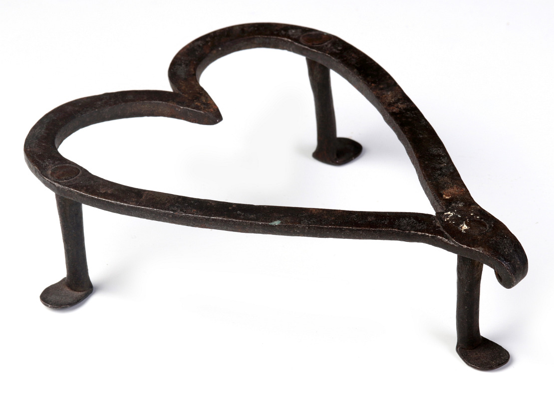 AN 18TH CENTURY FORGED IRON HEART FORM TRIVET 