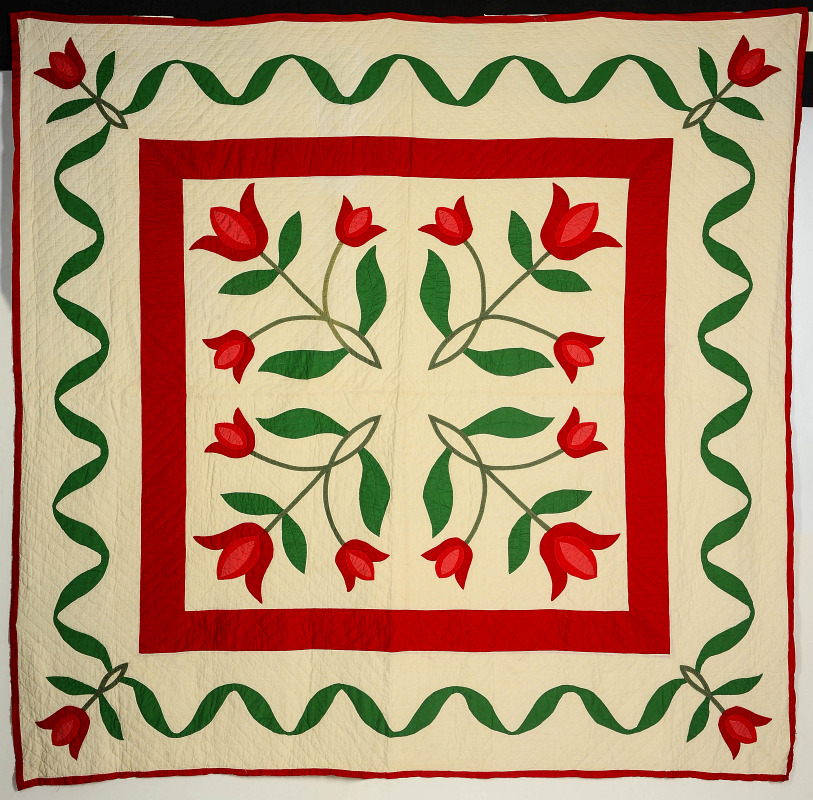 A VINTAGE RED AND GREEN APPLIQUE QUILT