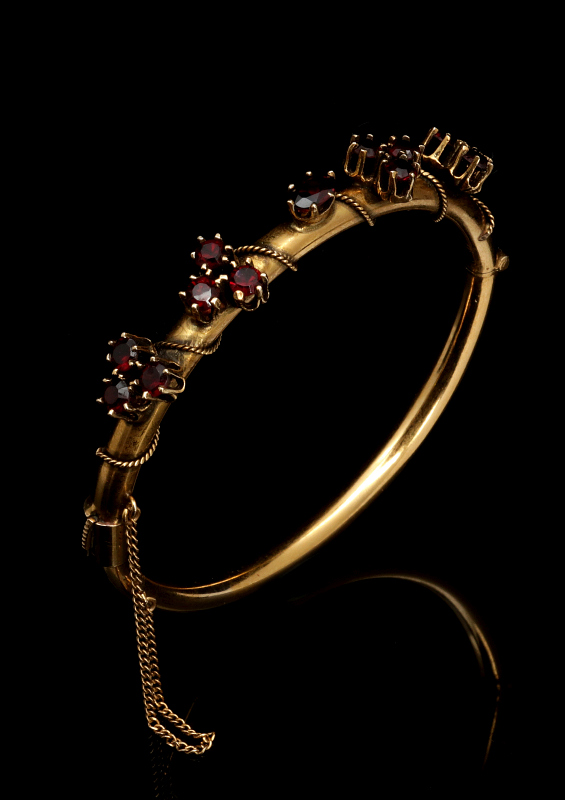 A 14K GOLD BANGLE BRACELET WITH GARNETS