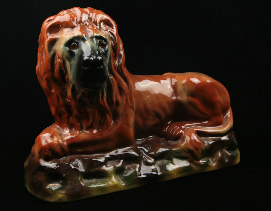 AN EARLY 20TH CENTURY STAFFORDSHIRE POTTERY LION 