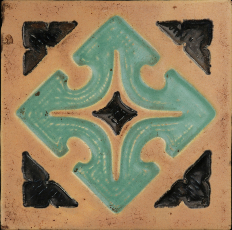 A CARVED AND GLAZED TERRA COTTA ARCHITECTURAL TILE