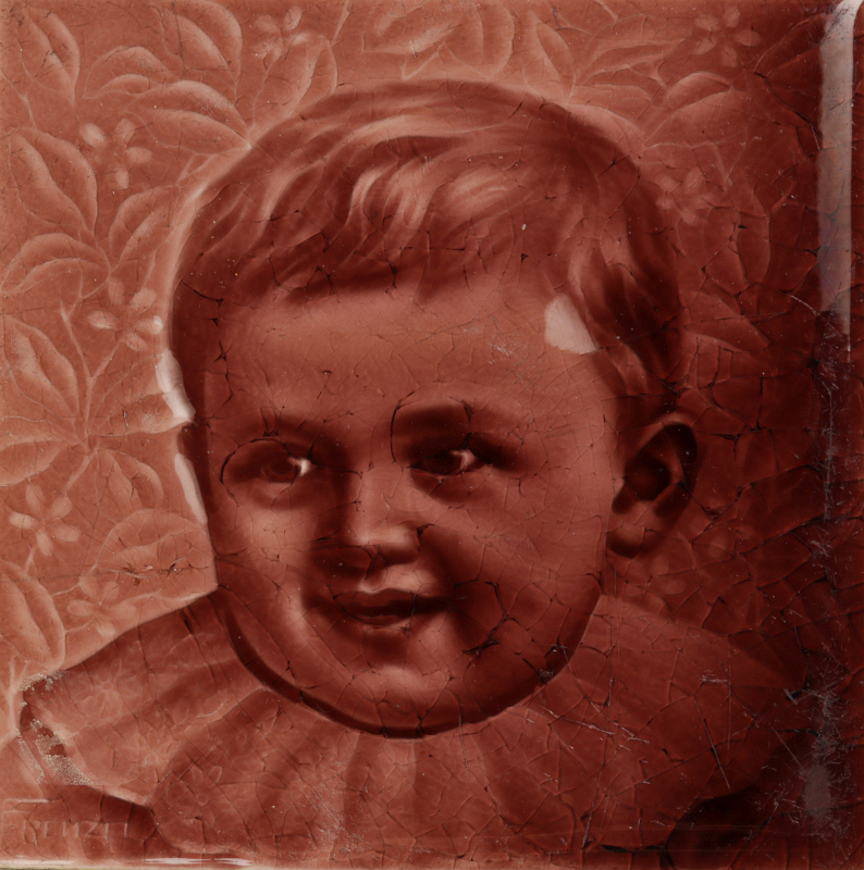 A 19TH C. GLAZED TILE WITH A PORTRAIT OF A CHILD