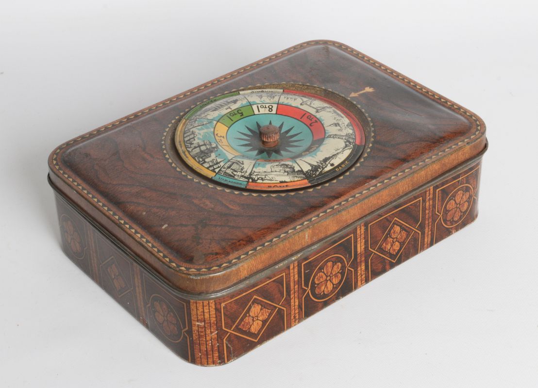 A TIN LITHO BISCUIT TIN W/ SPINNING ROULETTE GAME