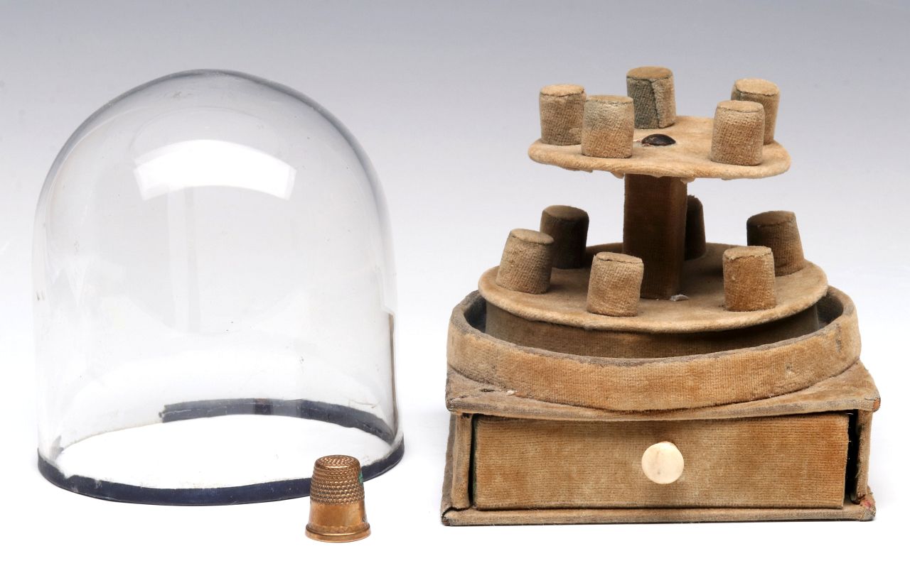 AN ANTIQUE SEWING THIMBLE STAND UNDER GLASS DOME