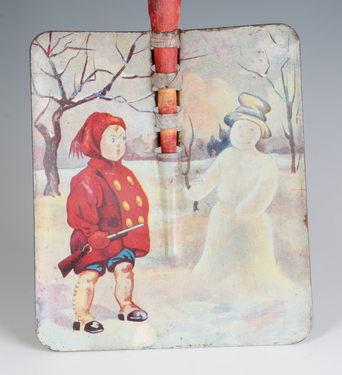 A CHILD'S TIN LITHO SNOW SHOVEL WITH WOOD HANDLE