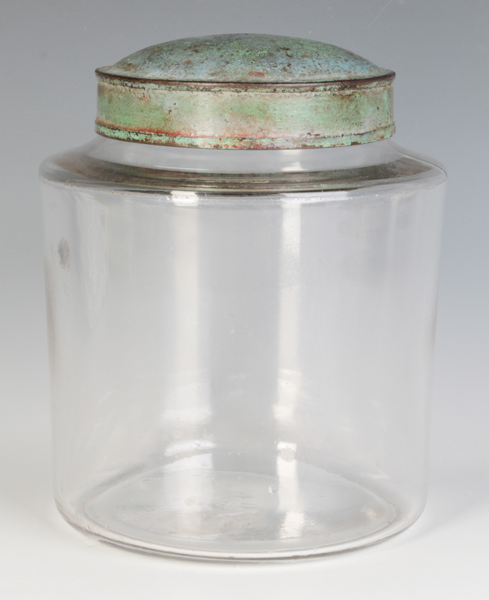 AN EARLY BLOWN GLASS STORAGE JAR WITH TOLE LID