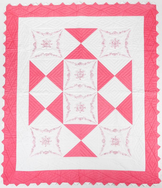 A VINTAGE PINK AND WHITE EMBROIDERED QUILT