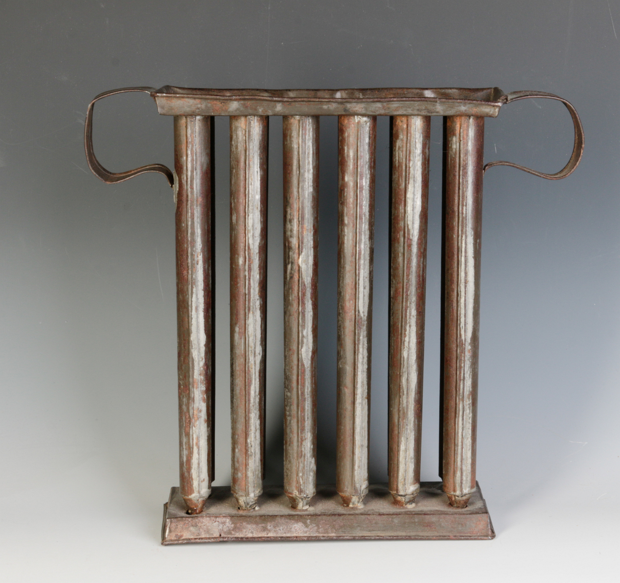 A 19TH CENTURY TIN CANDLE MOLD WITH TWELVE TUBES