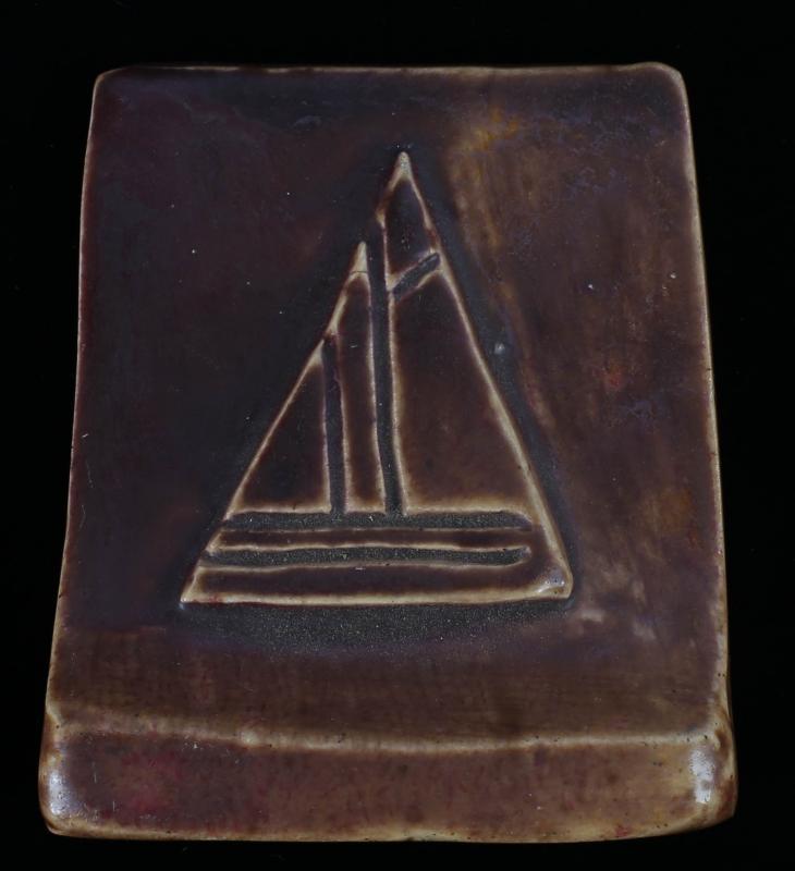 AN EARLY 20TH C. ART TILE WITH CARVED SAILBOAT