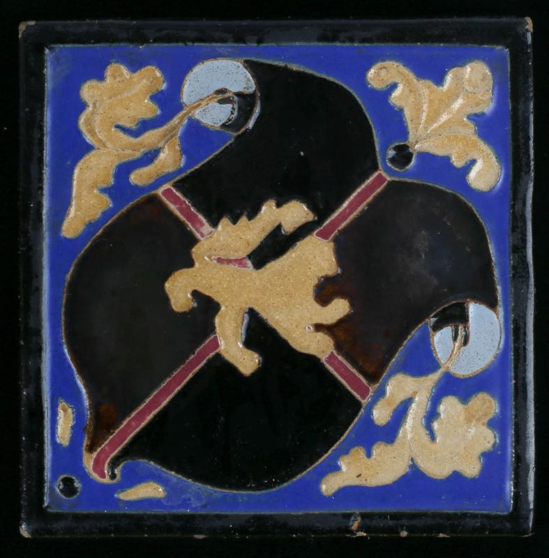 AN EARLY 20TH C. CARVED COAT-OF-ARMS TILE