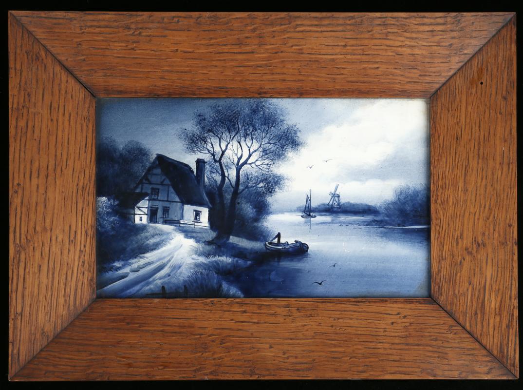 AN EARLY 20TH CENTURY DELFT PLAQUE IN OAK FRAME