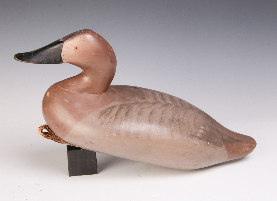 A CARVED AND PAINTED CANVAS BACK HEN DUCK DECOY