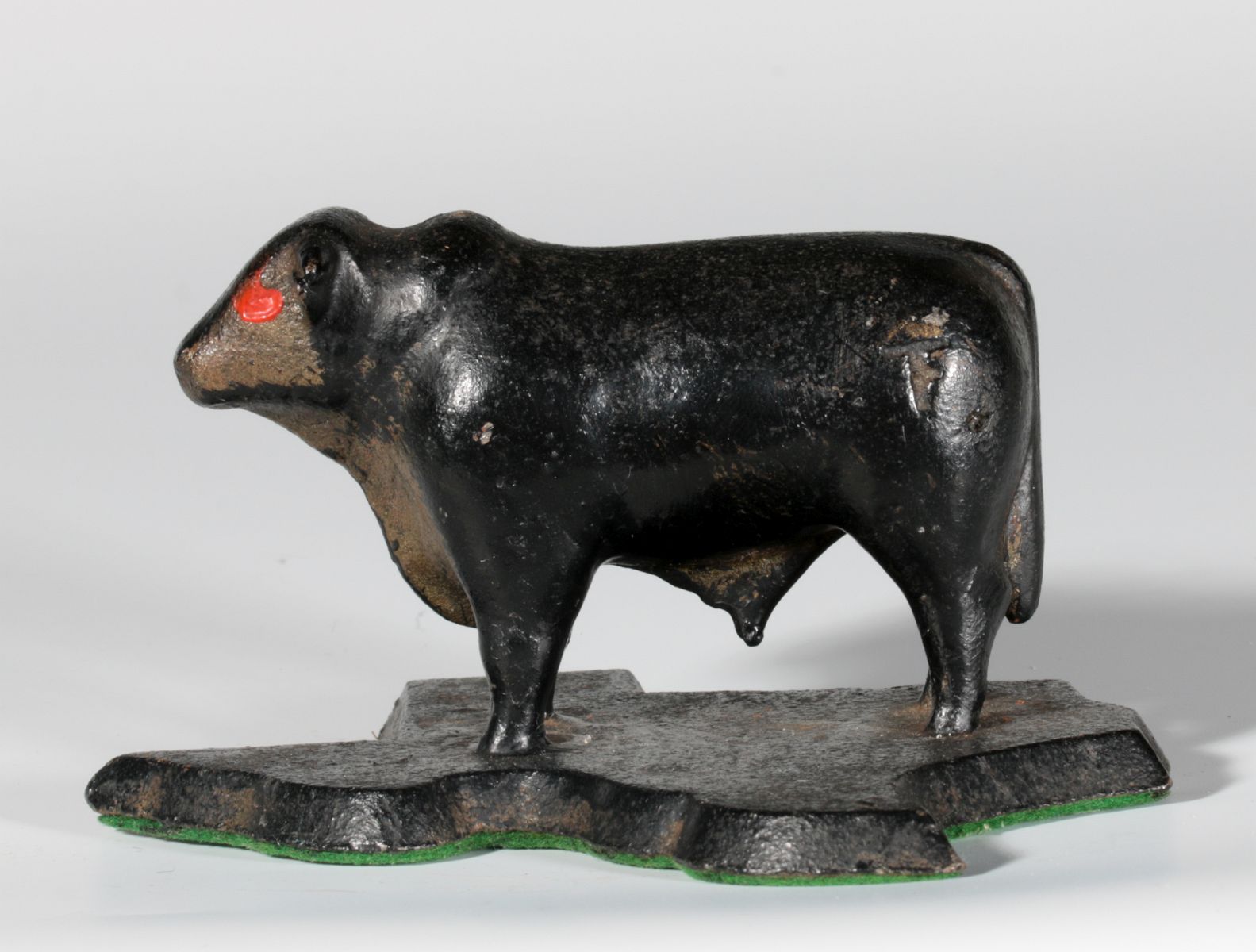 A CAST IRON PAPERWEIGHT - FIGURAL BULL ON TEXAS