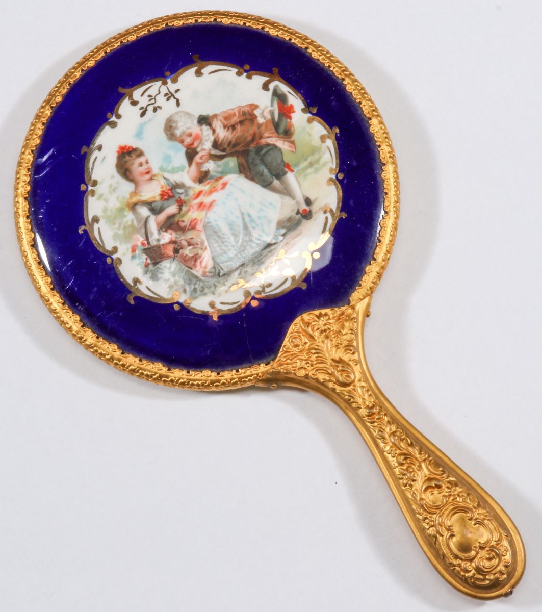 AN ANTIQUE HAND MIRROR WITH COURTING SCENE