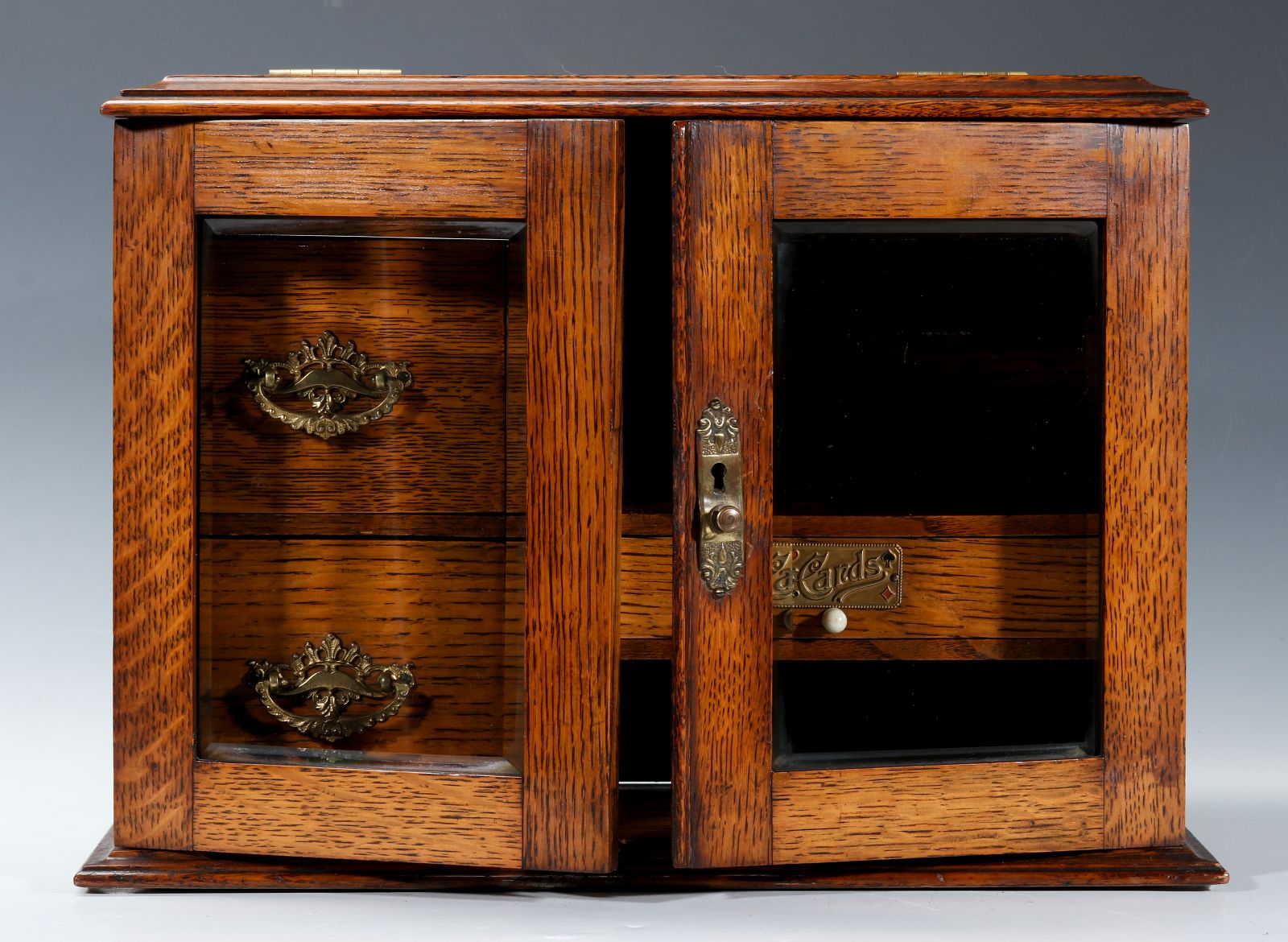 A CIRCA 1920s OAK PLAYING CARD AND GAMES CABINET
