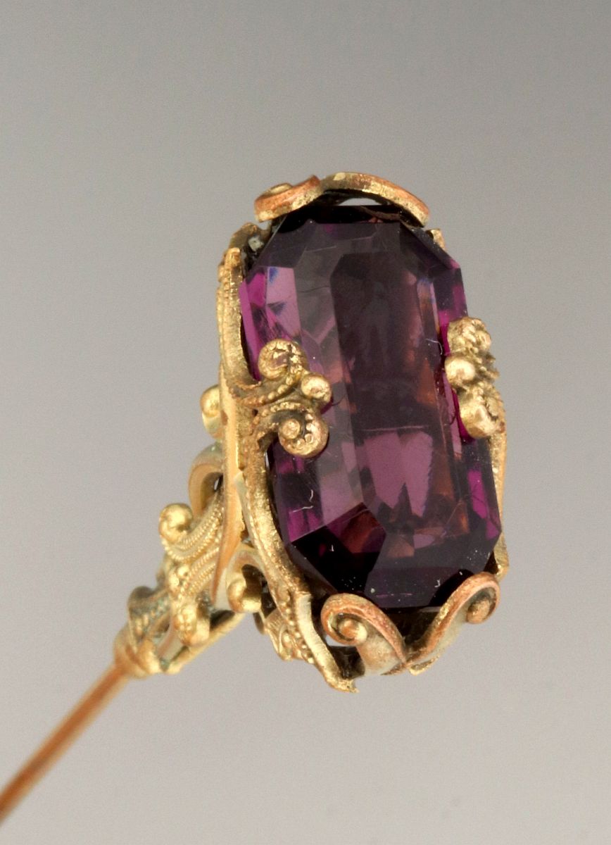 A GOLD FILLED VICTORIAN HAT PIN WITH PURPLE STONE