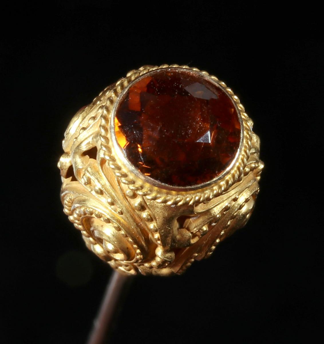AN ANTIQUE 14K GOLD HAT PIN WITH FACETED STONE