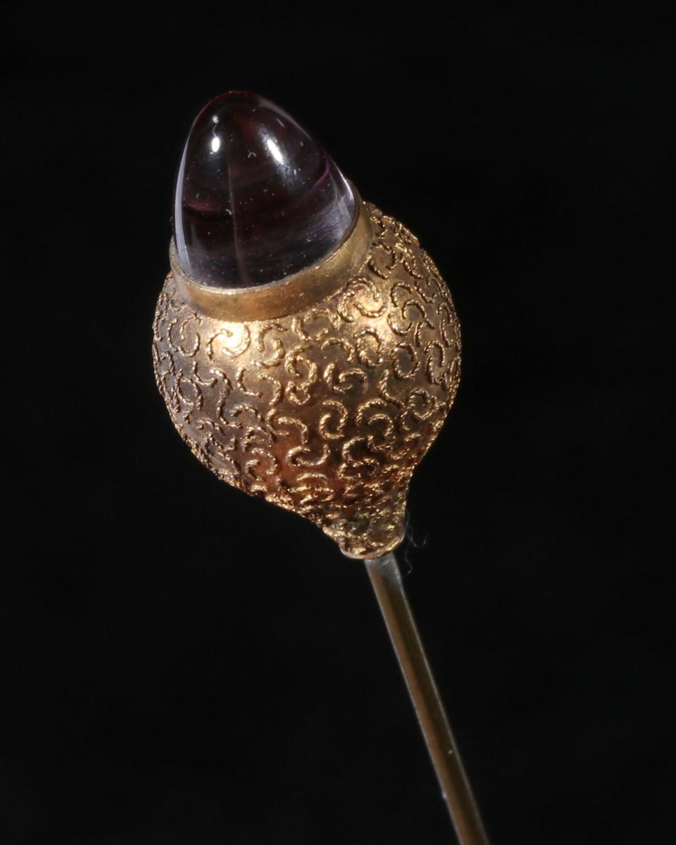 AN ANTIQUE GOLD-FILLED HAT PIN WITH CABOCHON