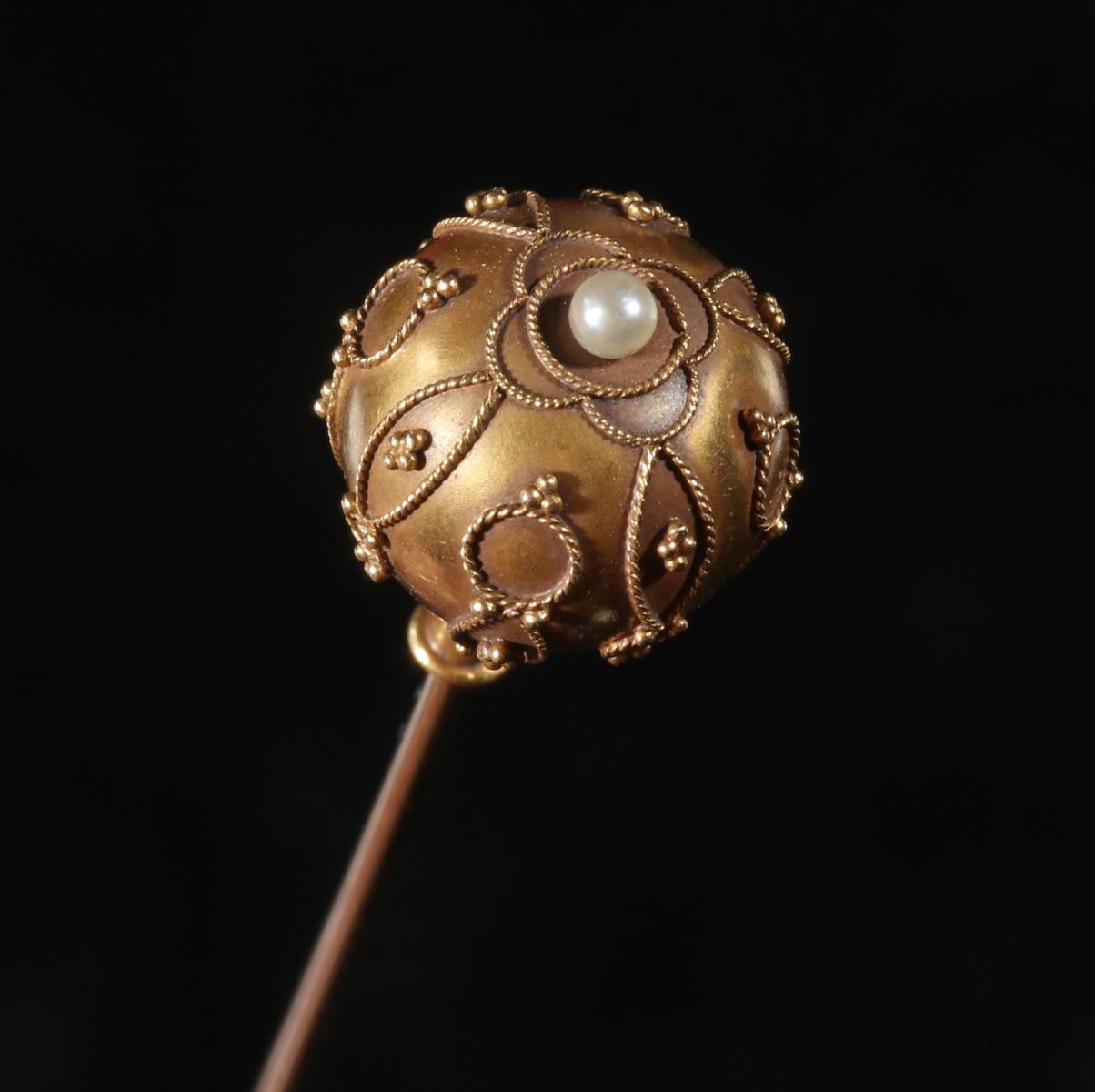 AN ANTIQUE GOLD-FILLED HAT PIN WITH ETRUSCAN WORK