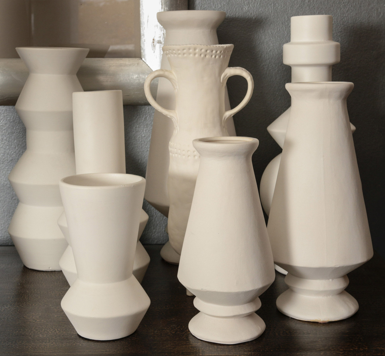 A COLLECTION OF EIGHT UNGLAZED BOTTLES AND VASES