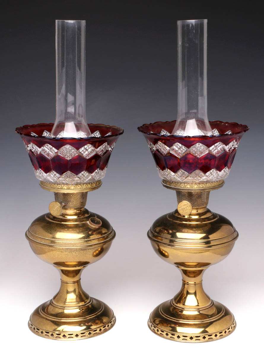 A PAIR BRASS ALADDIN LAMPS WITH RUBY FLASH SHADES