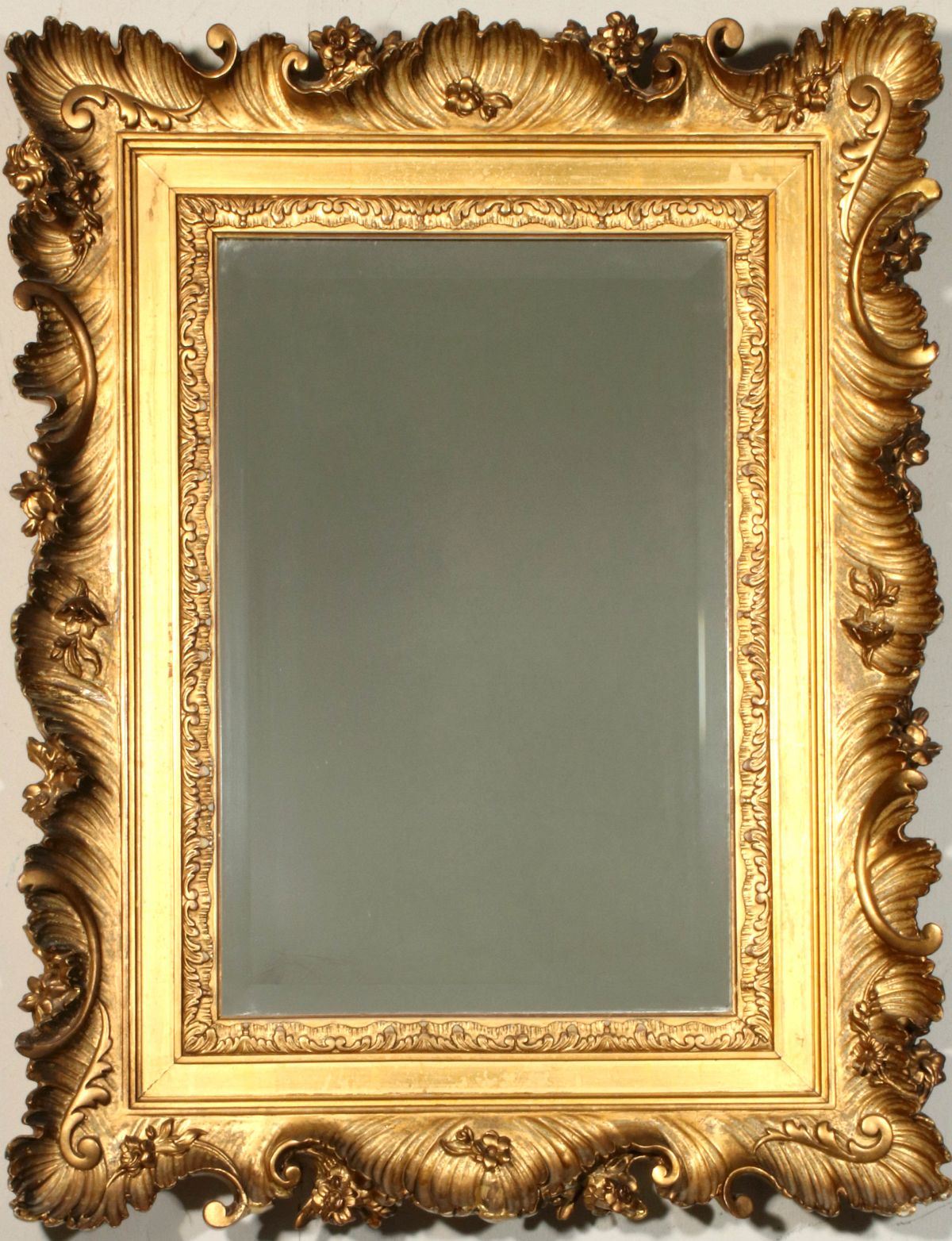 A 19TH CENTURY MIRROR WITH HEAVY ROCOCO FRAME