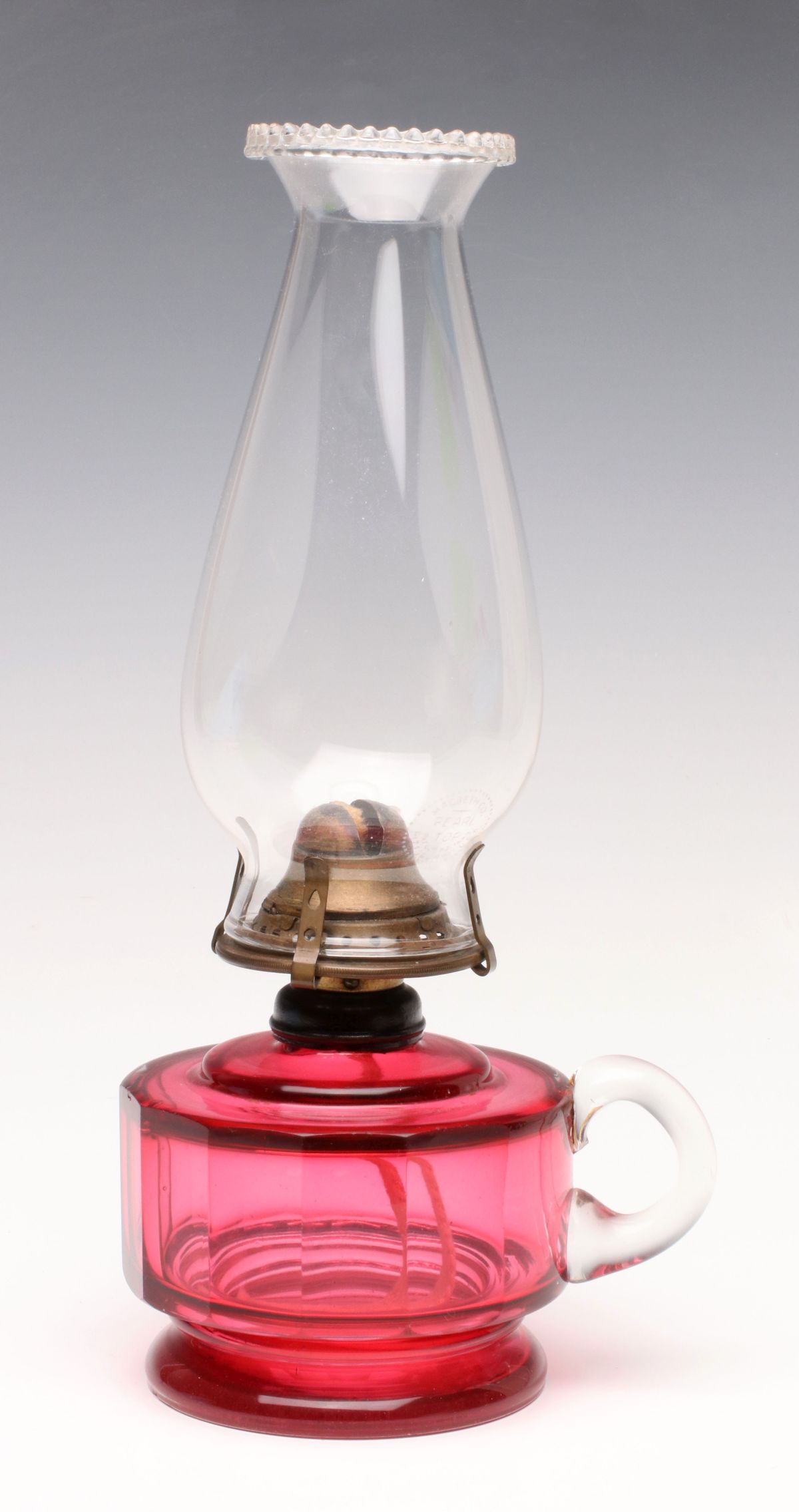 A CUT AND POLISHED CRANBERRY GLASS FINGER LAMP