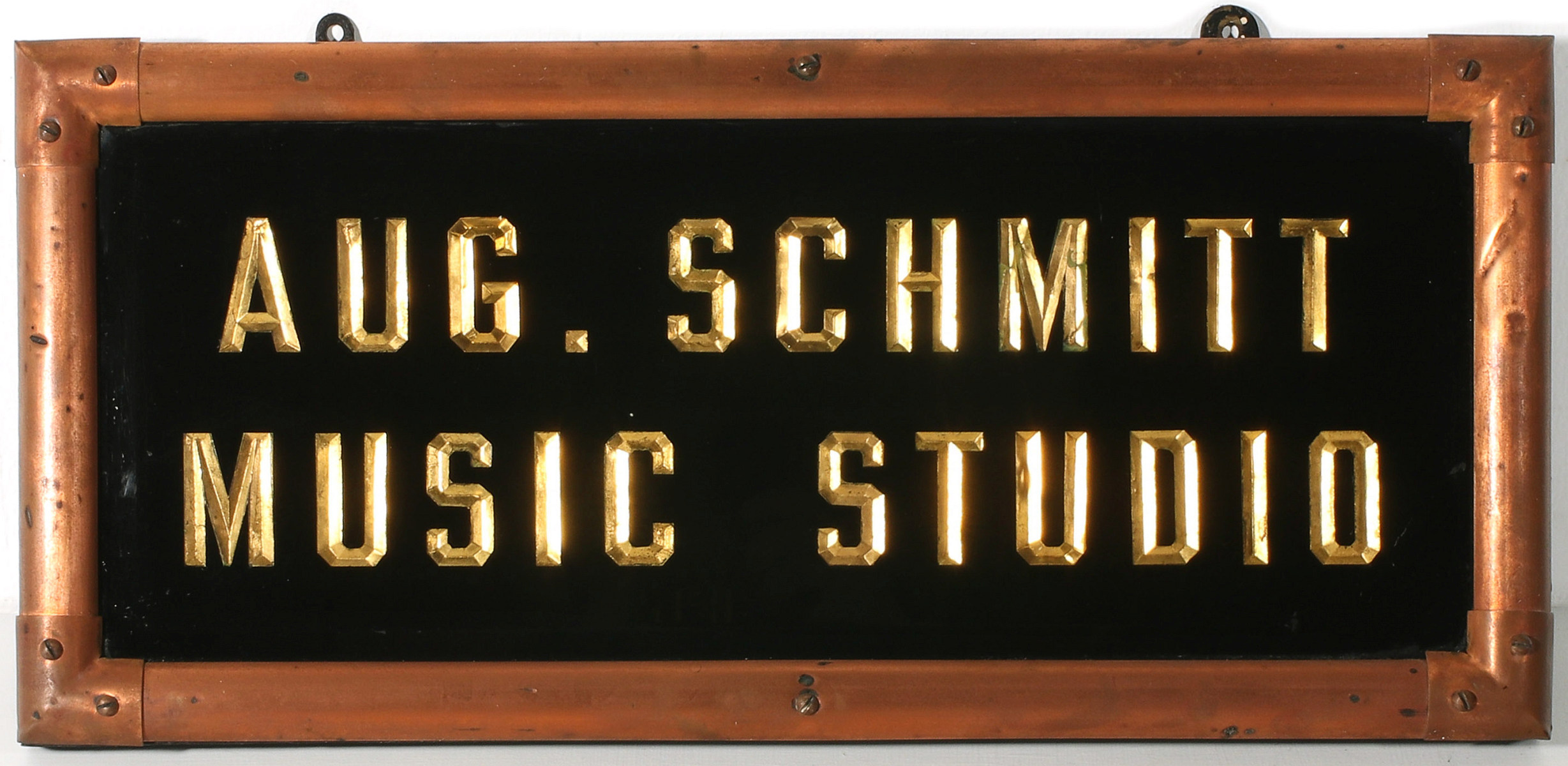 A REVERSE GOLD LETTERED SIGN FOR AUG. SCHMITT MUSIC