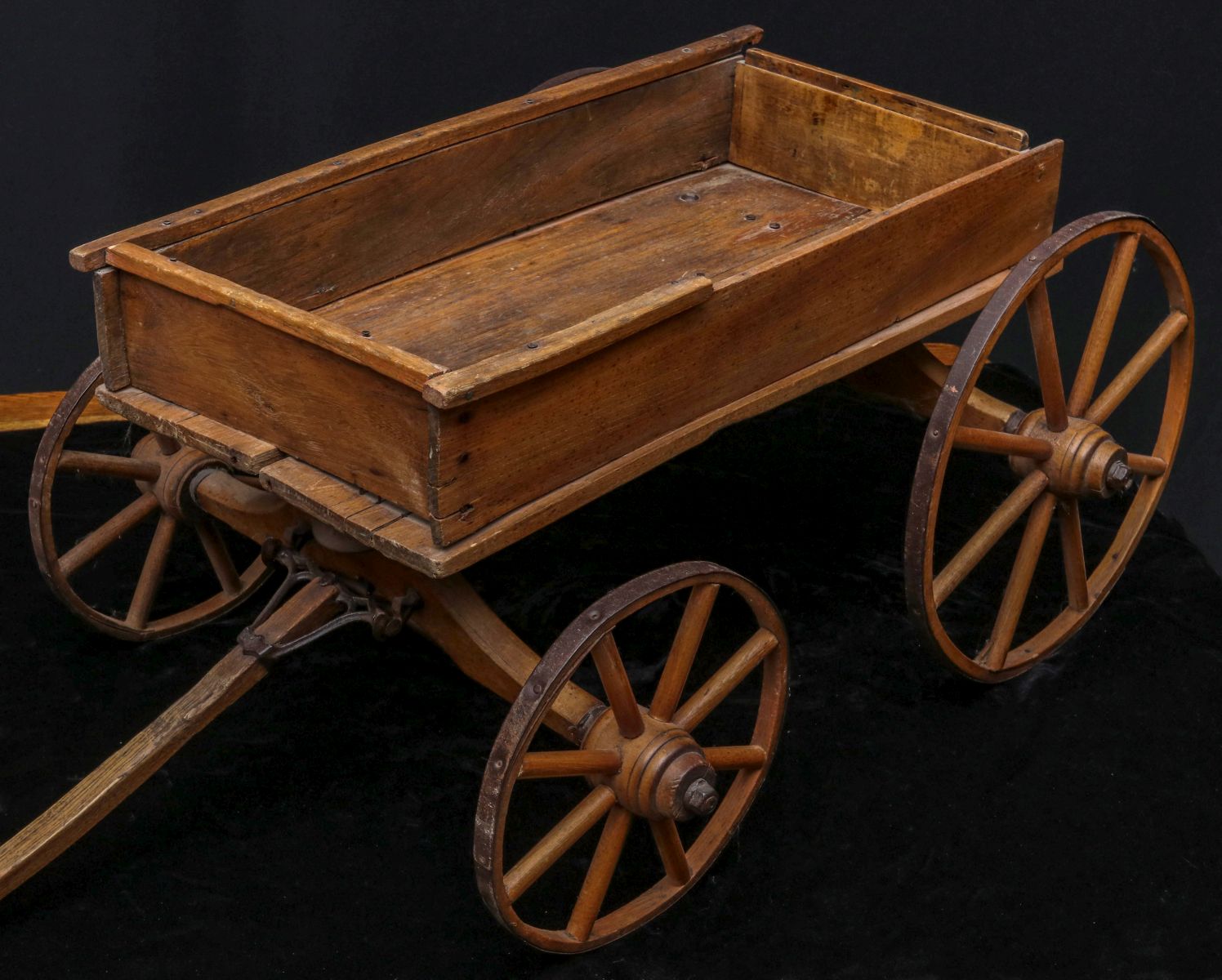 AN ANTIQUE CHILD'S COASTER WAGON WITH WOOD SPOKE WHEELS