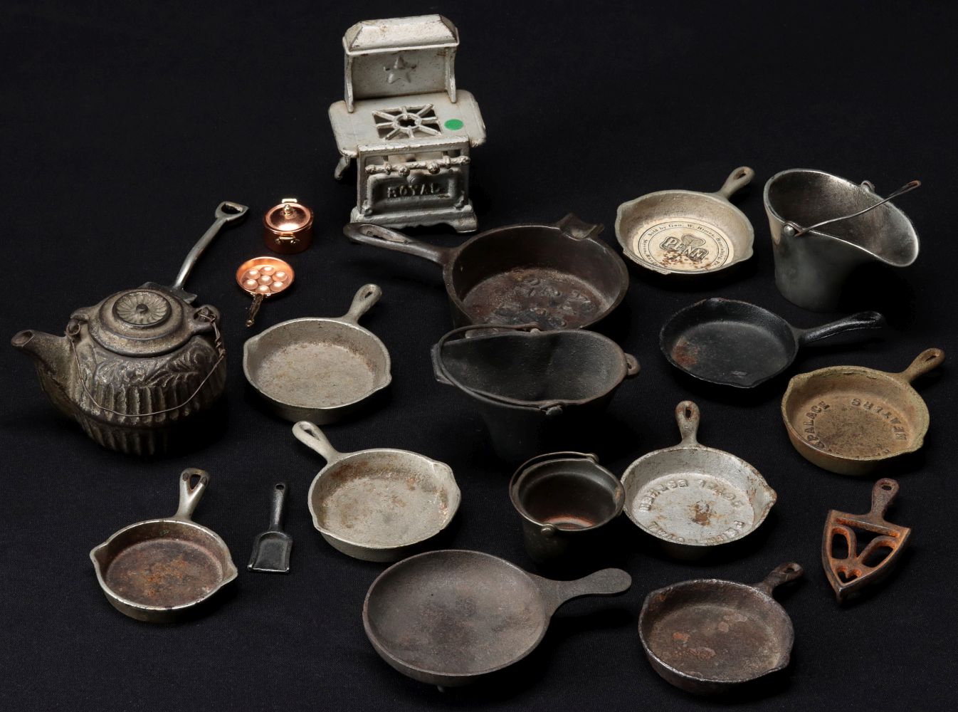 A LARGE COLLECTION OF ANTIQUE MINIATURE IRON COOKWARE