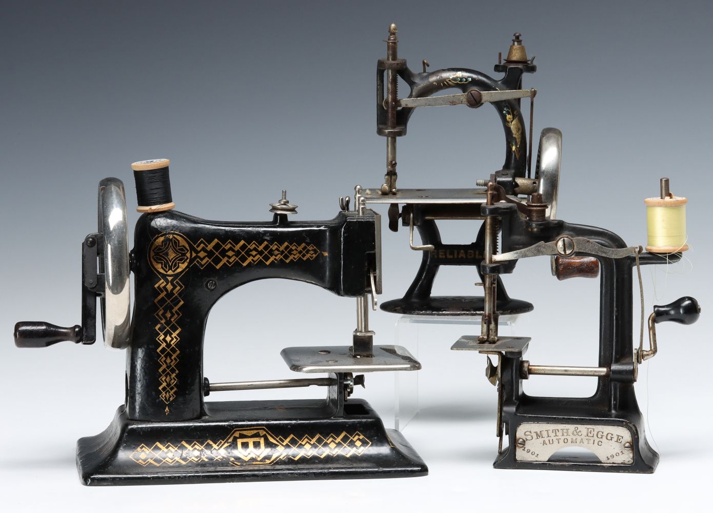 THREE GOOD EARLY 20TH C. CAST IRON TOY SEWING MACHINES