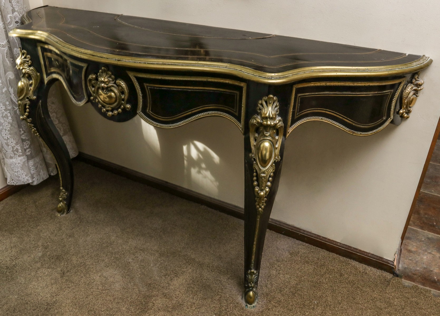 A FRENCH STYLE EBONISED CONSOLE WITH BRASS INLAYS
