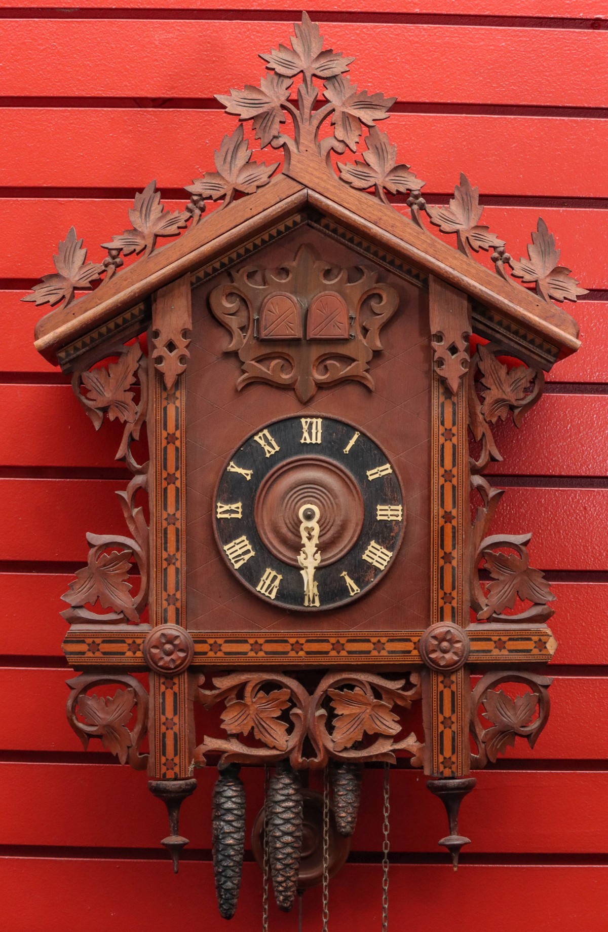 AN EARLY 20TH C. CUCKOO CLOCK WITH CARVING AND INLAY
