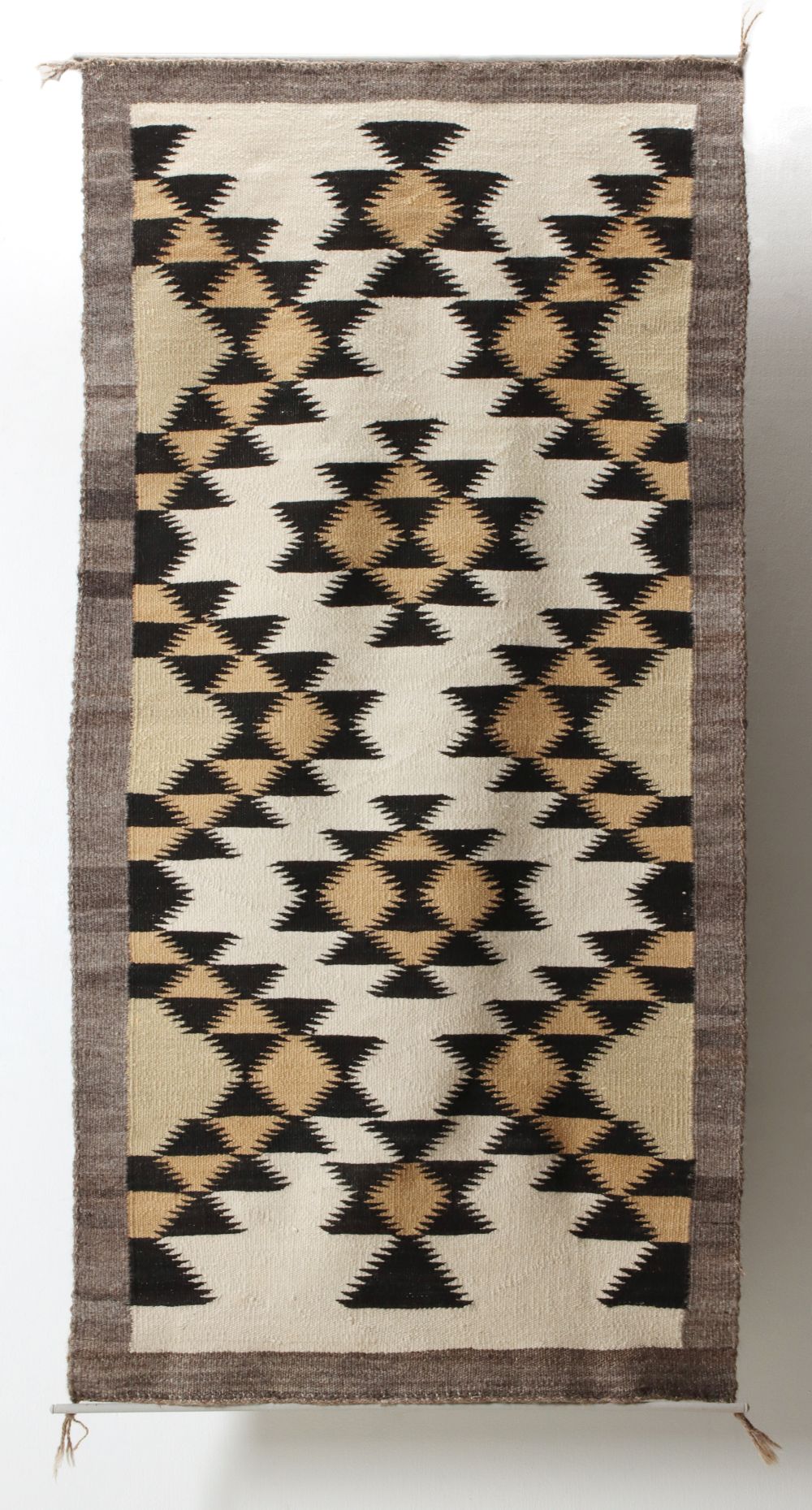 A NAVAJO WEAVING WITH SERRATED DESIGNS
