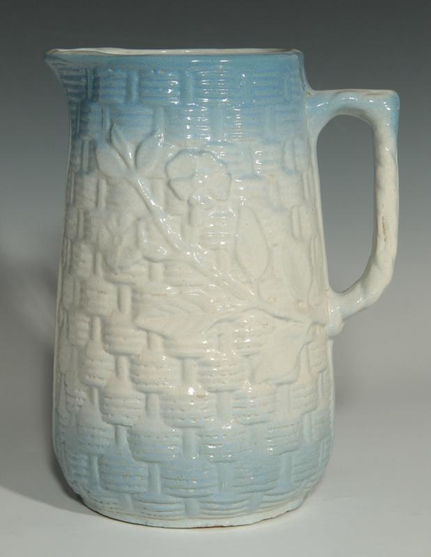 AN ANTIQUE BLUE AND WHITE PITCHER WITH ROSES