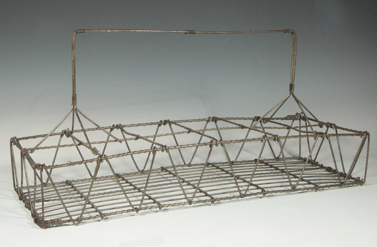 AN ANTIQUE TWELVE COMPARTMENT WIRE WORK CARRIER
