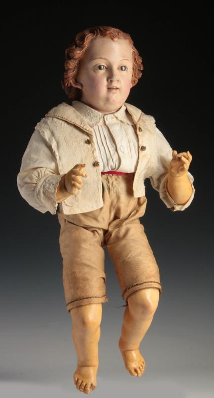 A CARVED AND GESSOED WOOD CHILD WITH GLASS EYES