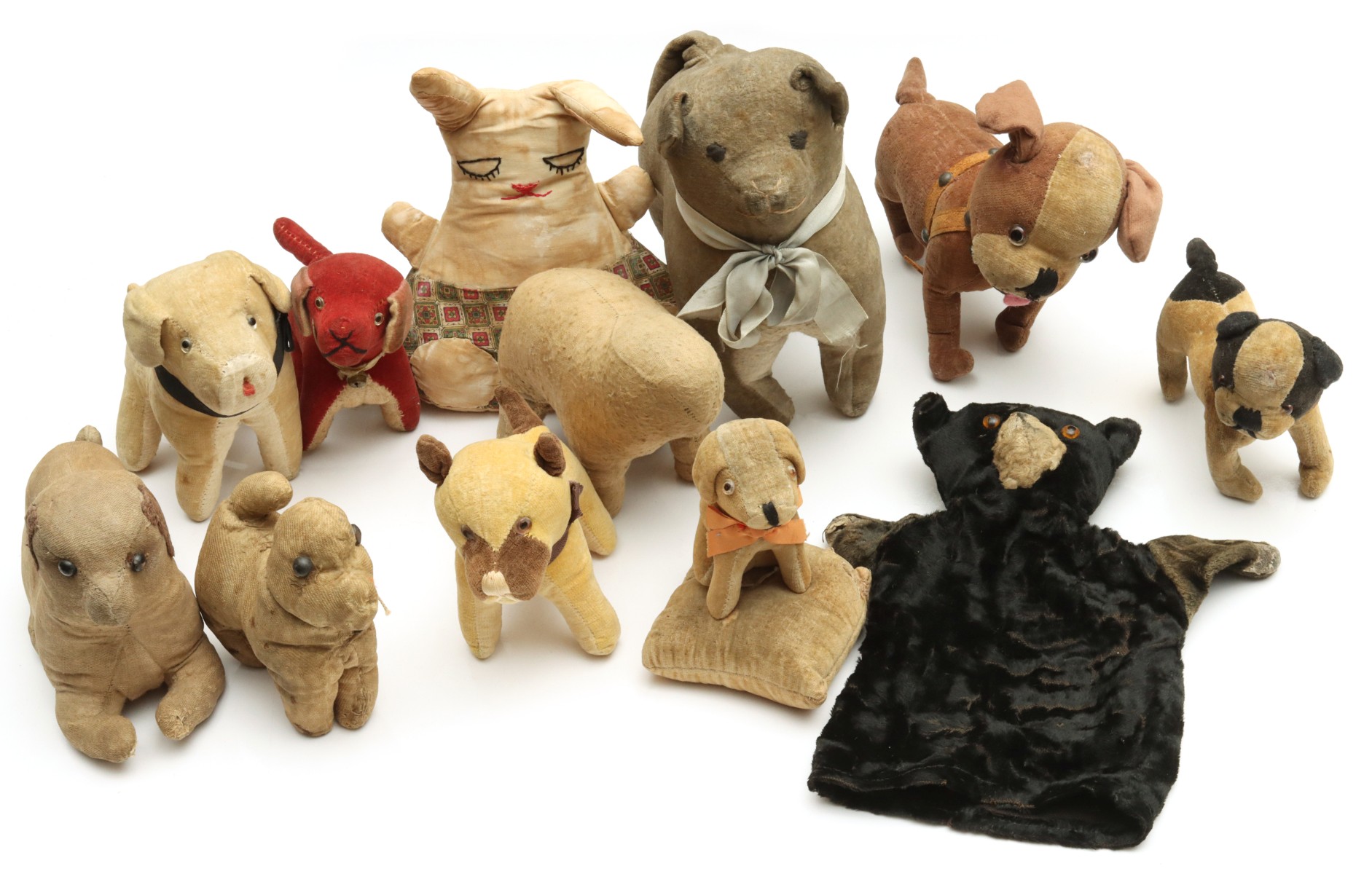 ELEVEN EARLY PRIMITIVE STRAW AND OTHER STUFFED DOGS