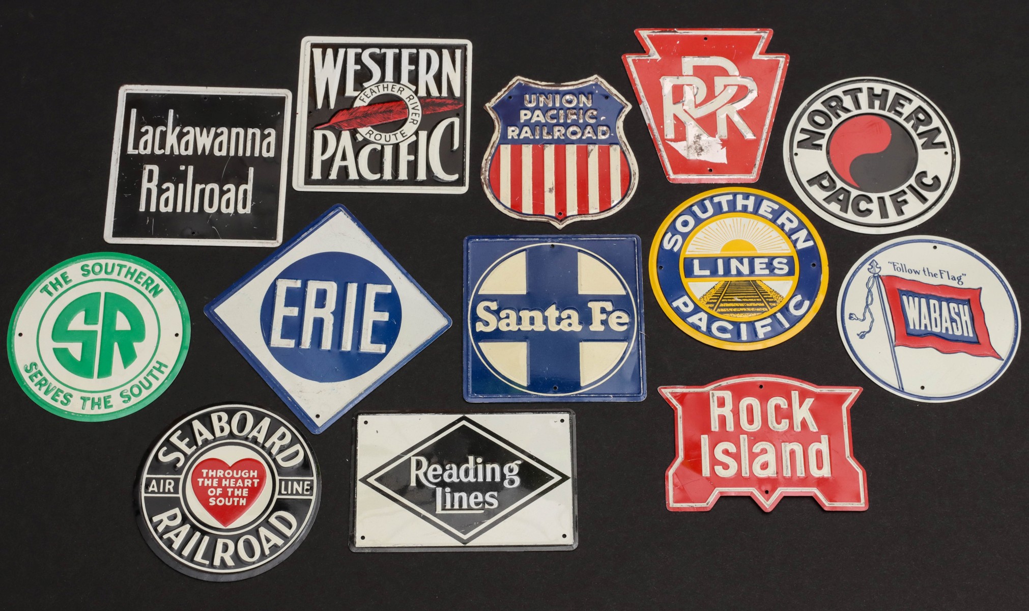 A COLLECTION OF 13 EMBOSSED TIN LITHO RAILROAD BADGES