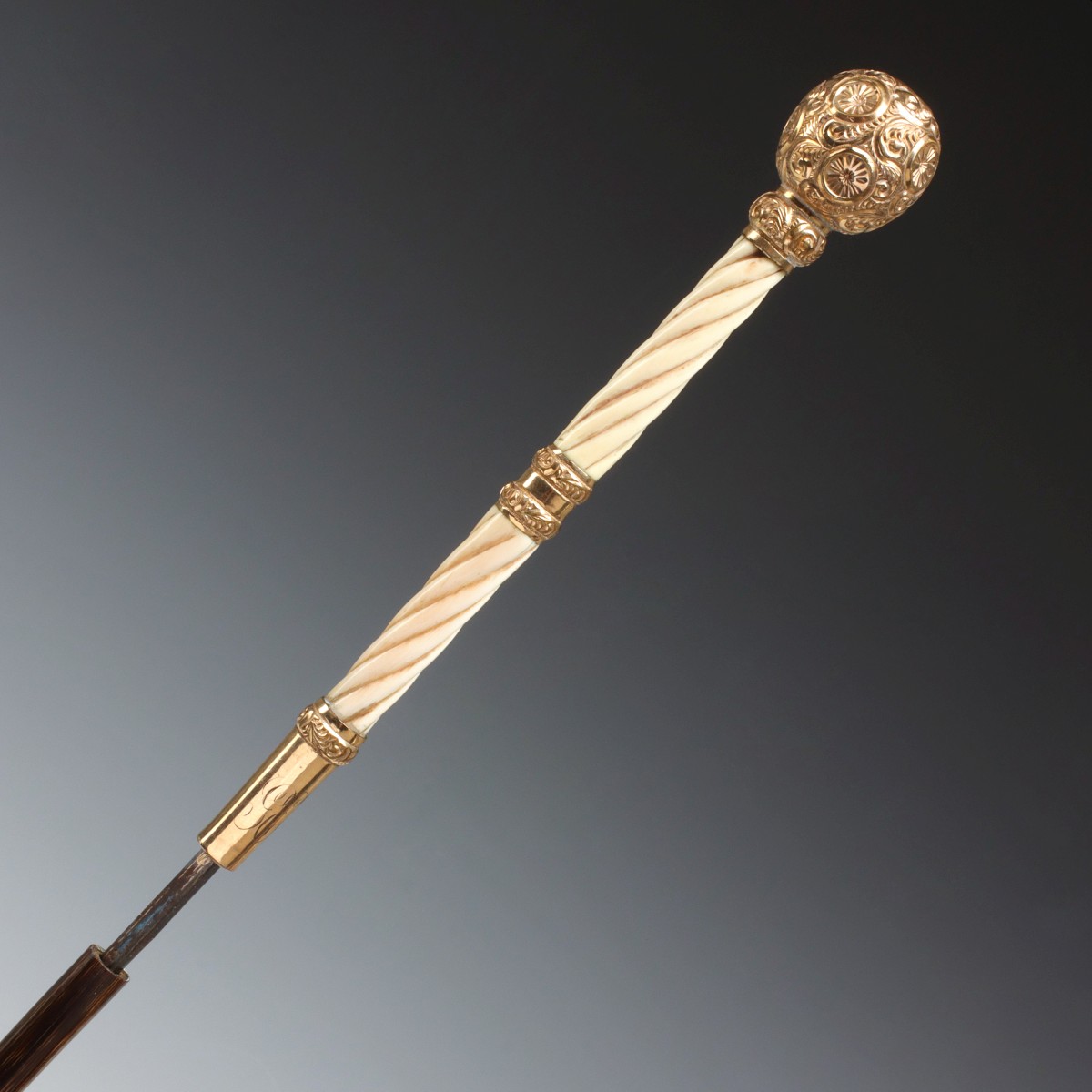 A GOLD FILLED, IVORY AND PARTRIDGE WOOD DAGGER CANE