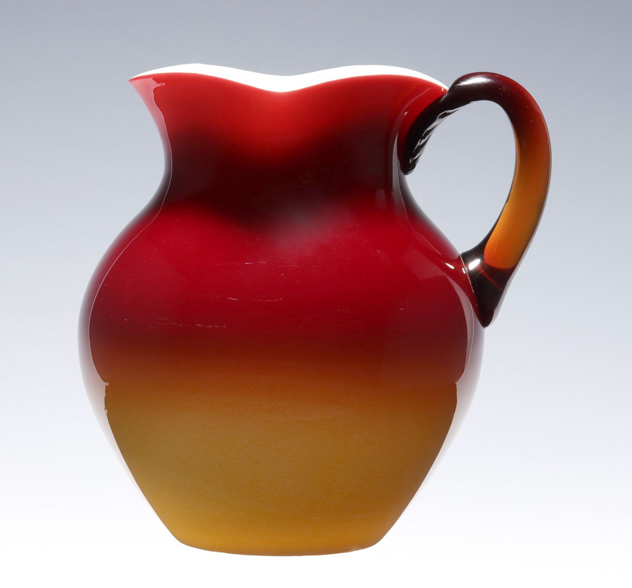 A WHEELING PEACHBLOW PITCHER WITH AMBER HANDLE