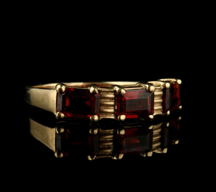 A 10K GOLD RING WITH RED STONES